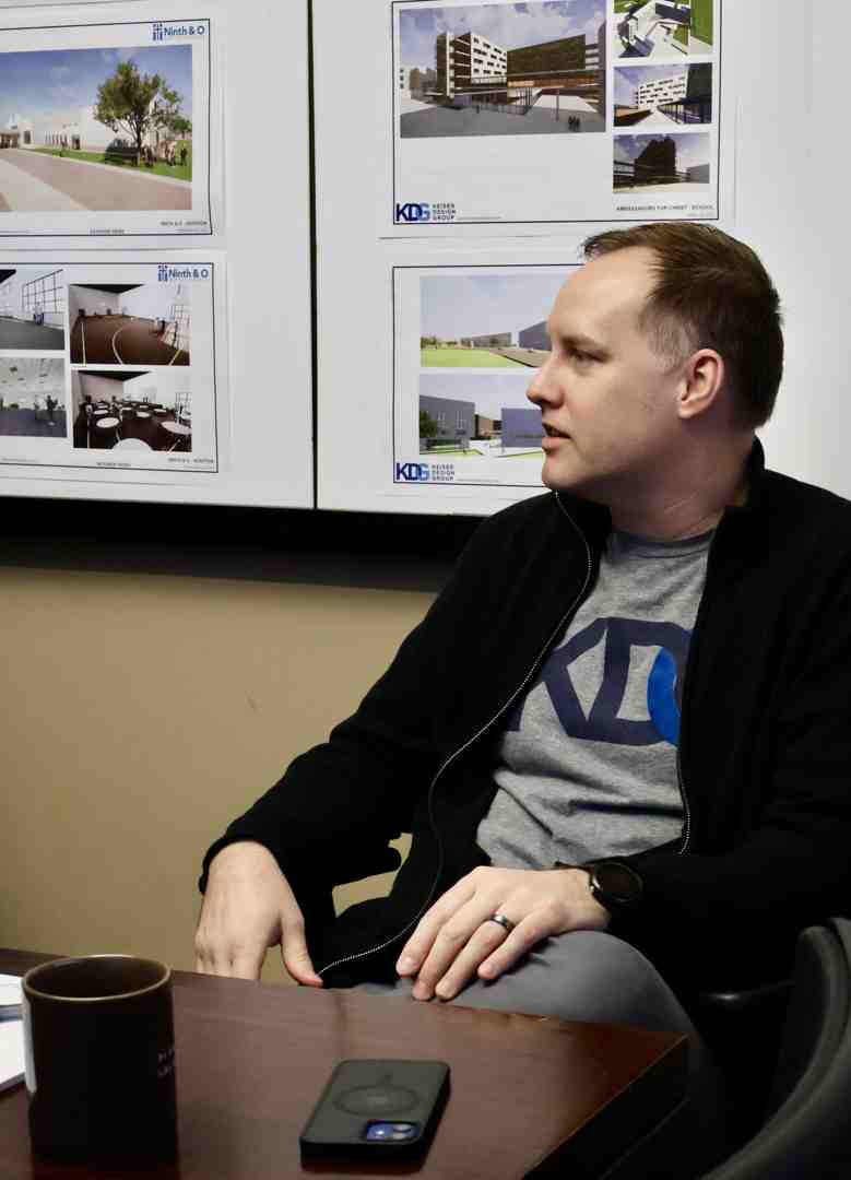 collaborative meeting between clients and architects around a table with models and drawings - commercial architects