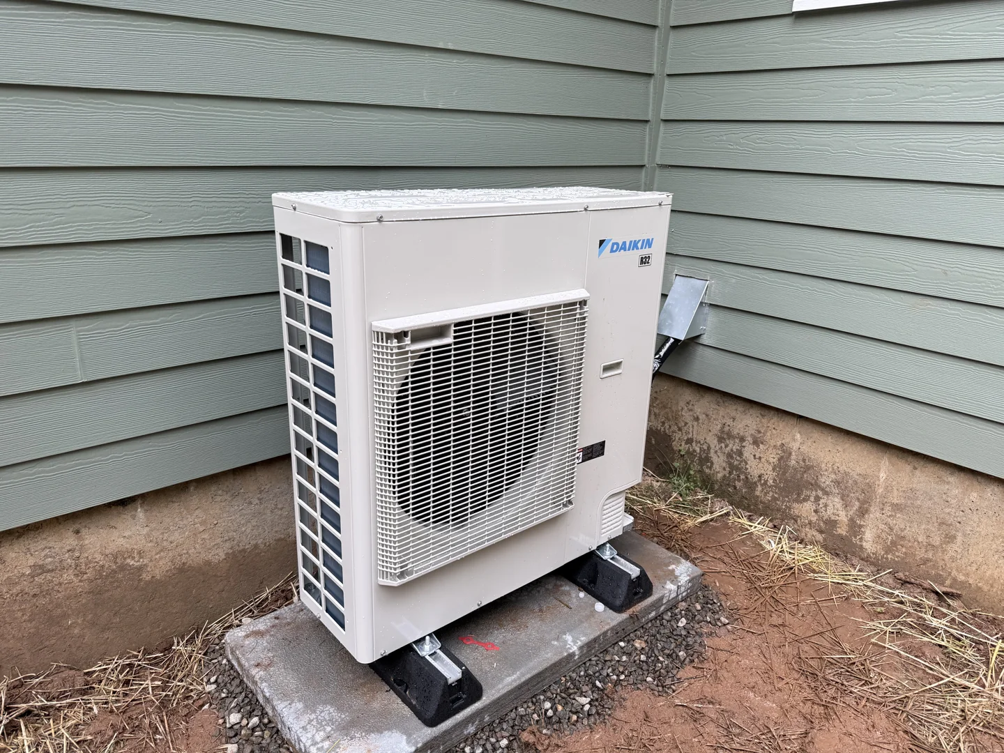 Outdoor heat pump beside rainy Southwest Washington home with wet leaves around unit Outdoor heat pump beside rainy Southwest Washington home with wet leaves around unit