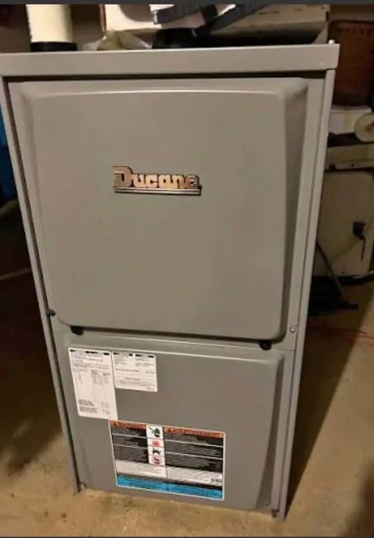 An aging furnace in a Glenview basement showing signs of wear and rust on the exterior cabinet - furnace replacement