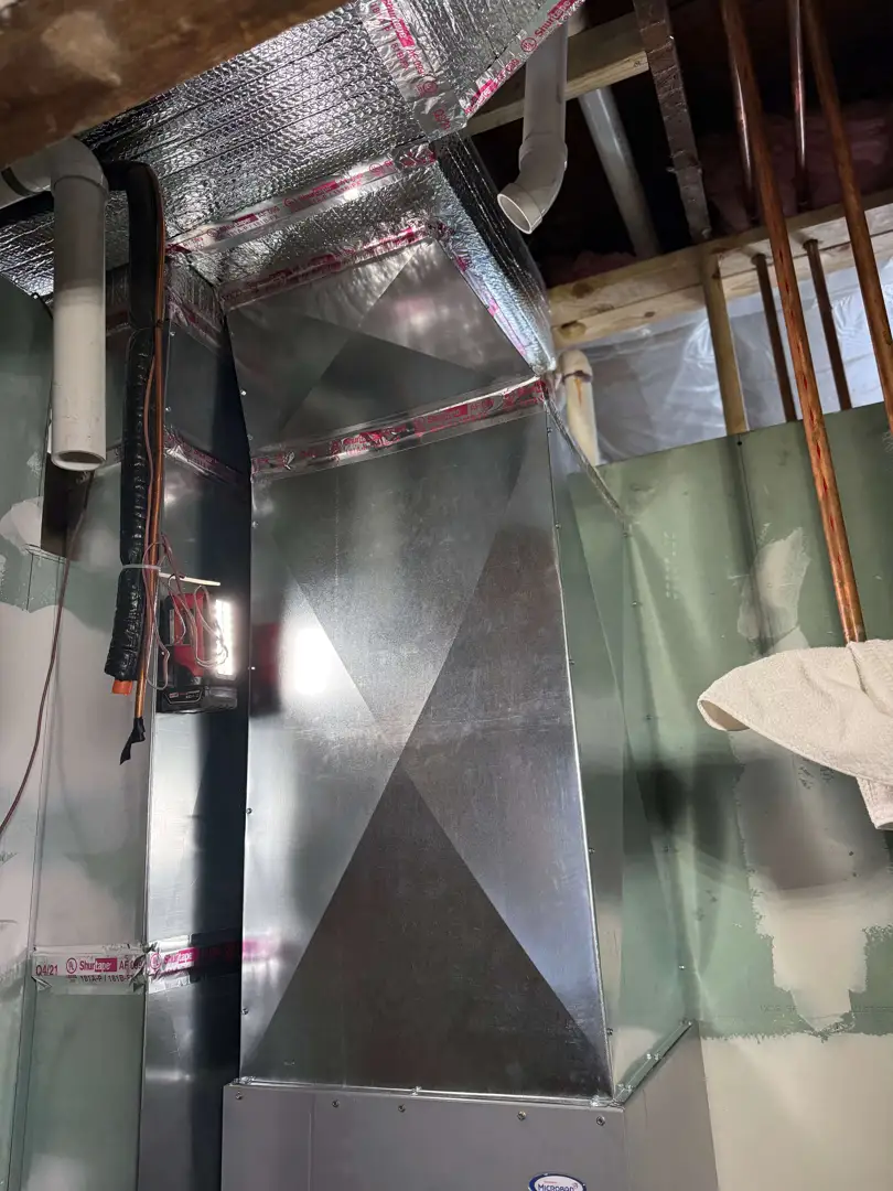 A professional technician inspecting dusty ductwork in a Glenview home basement - indoor air quality solution A professional technician inspecting dusty ductwork in a Glenview home basement - indoor air quality solution