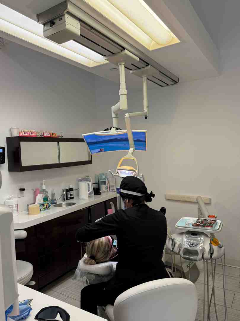 dentist using a blue curing light on a patient's tooth - composite filling material