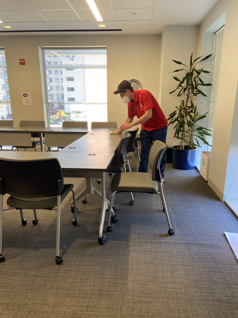Red Coats professional using biodegradable cleaning supplies in a modern office Red Coats professional using biodegradable cleaning supplies in a modern office