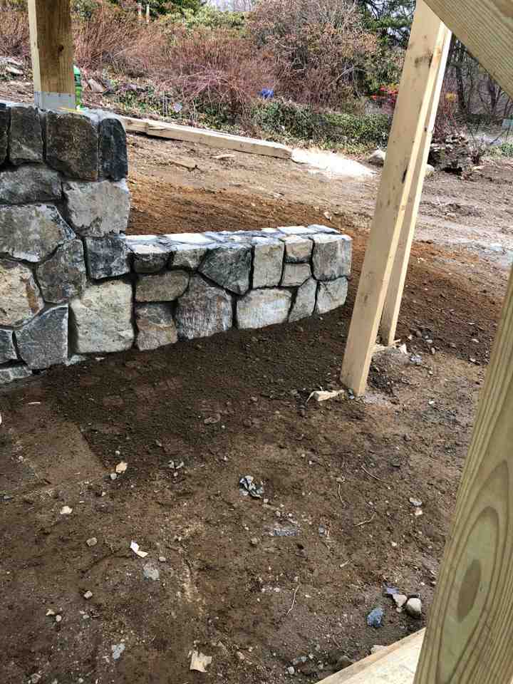Beautiful completed masonry project showing outdoor living space with stone walls and patio - mason construction