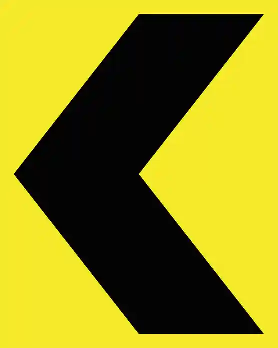 A yellow and black chevron sign, a key component of directional signage systems for road safety.