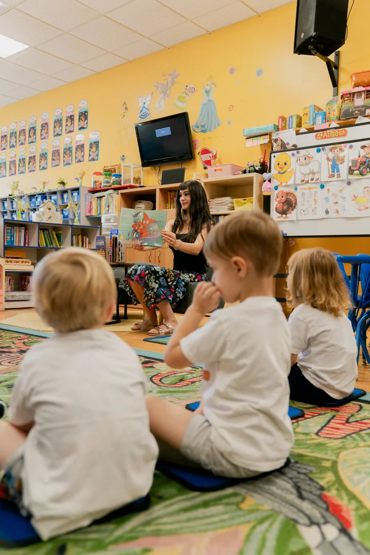 Teacher guiding preschoolers through an interactive group listening activity