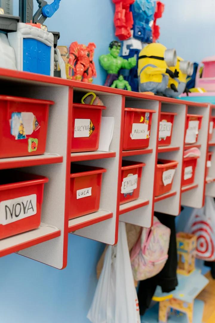 preschoolers hanging up backpacks and jackets in classroom cubbies preschoolers hanging up backpacks and jackets in classroom cubbies
