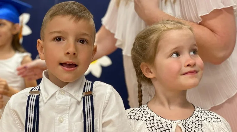 Child smiling happily during preschool graduation