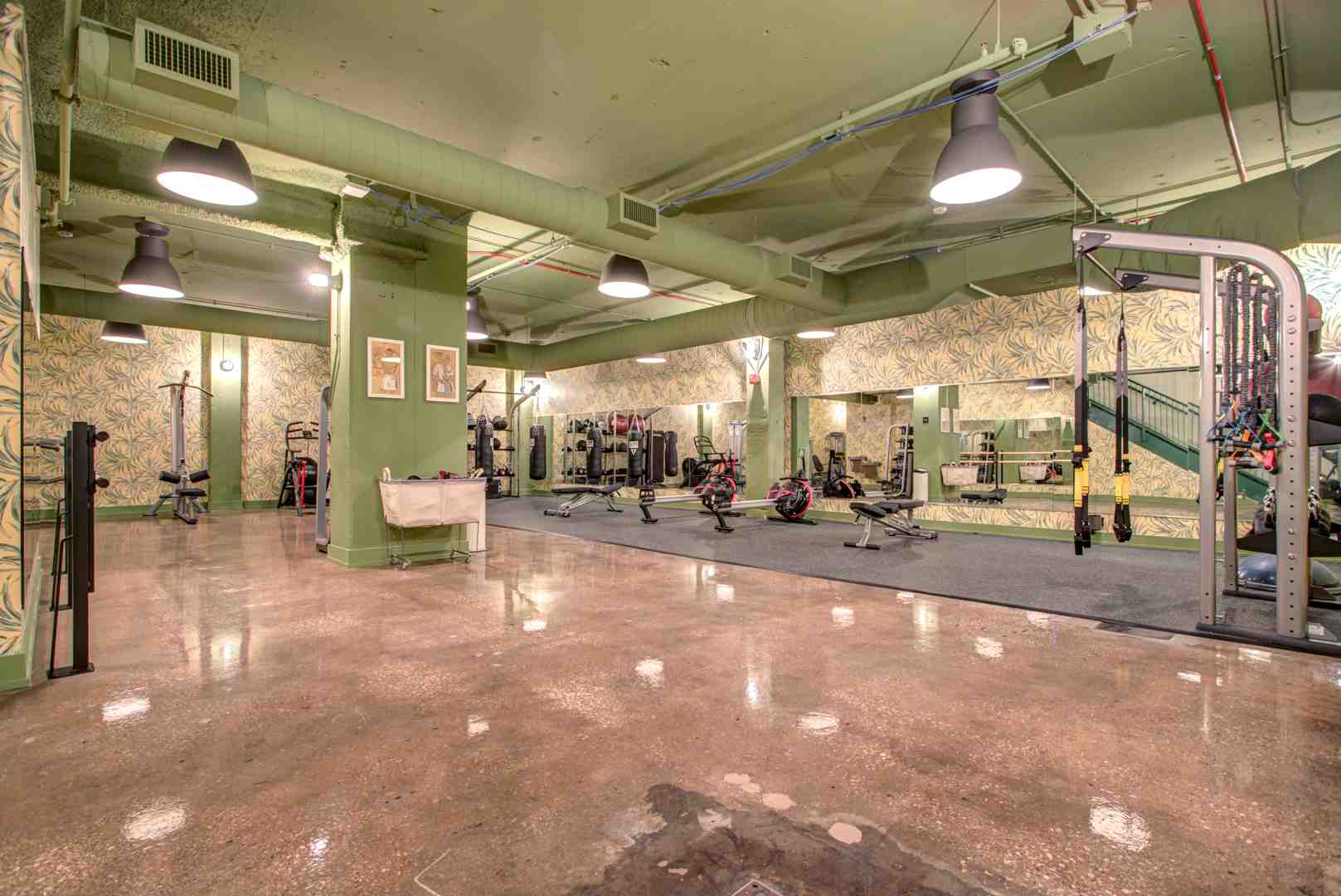 Modern apartment fitness center with city views - apartments with resort amenities