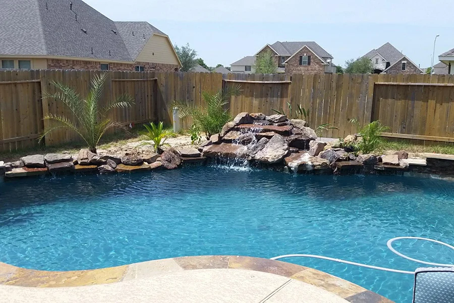 Flat Houston backyard with a custom pool and a rock waterfall Flat Houston backyard with a custom pool and a rock waterfall