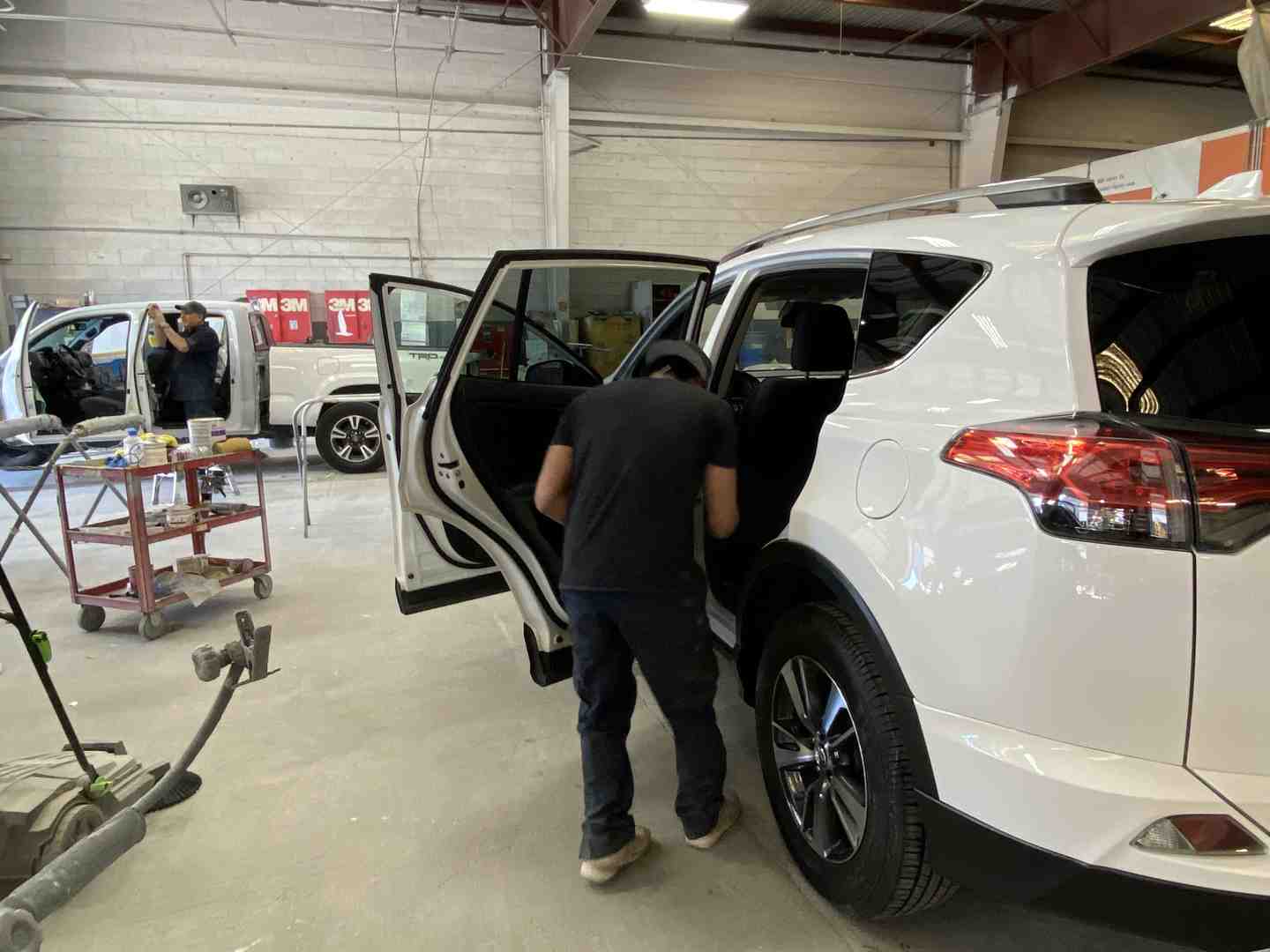 car being inspected at a clean, professional auto body shop - tow company near me