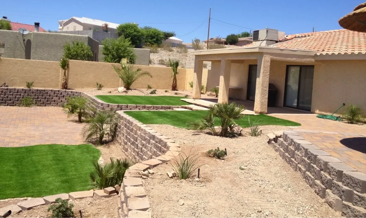 A completed residential turf project featuring clean stone borders and desert-hardy plants