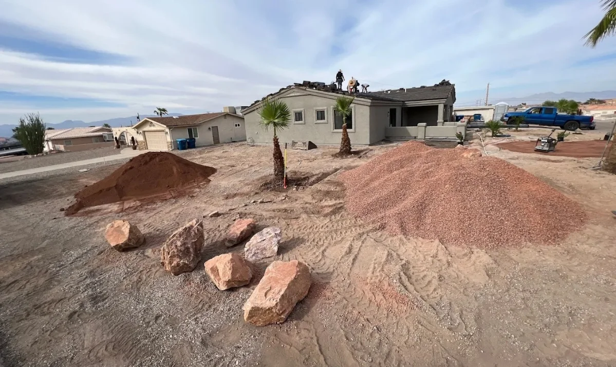 Landscapers conditioning rocky desert soil and preparing swales for site drainage Landscapers conditioning rocky desert soil and preparing swales for site drainage