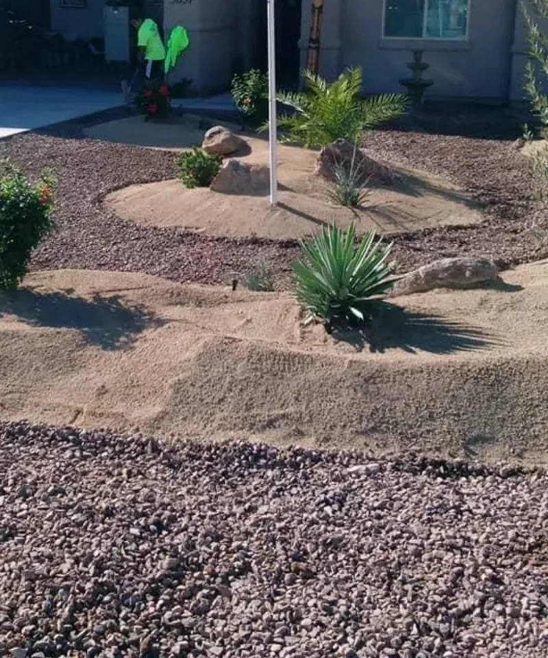 A dry riverbed with mixed river rock and boulders in an Arizona front yard