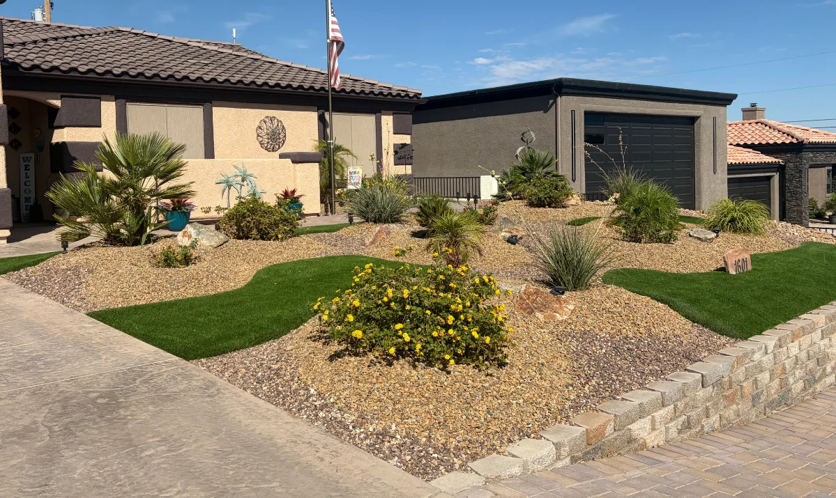 Neatly manicured low-water front yard featuring layered shrubs, rock mulch, and drip lines Neatly manicured low-water front yard featuring layered shrubs, rock mulch, and drip lines