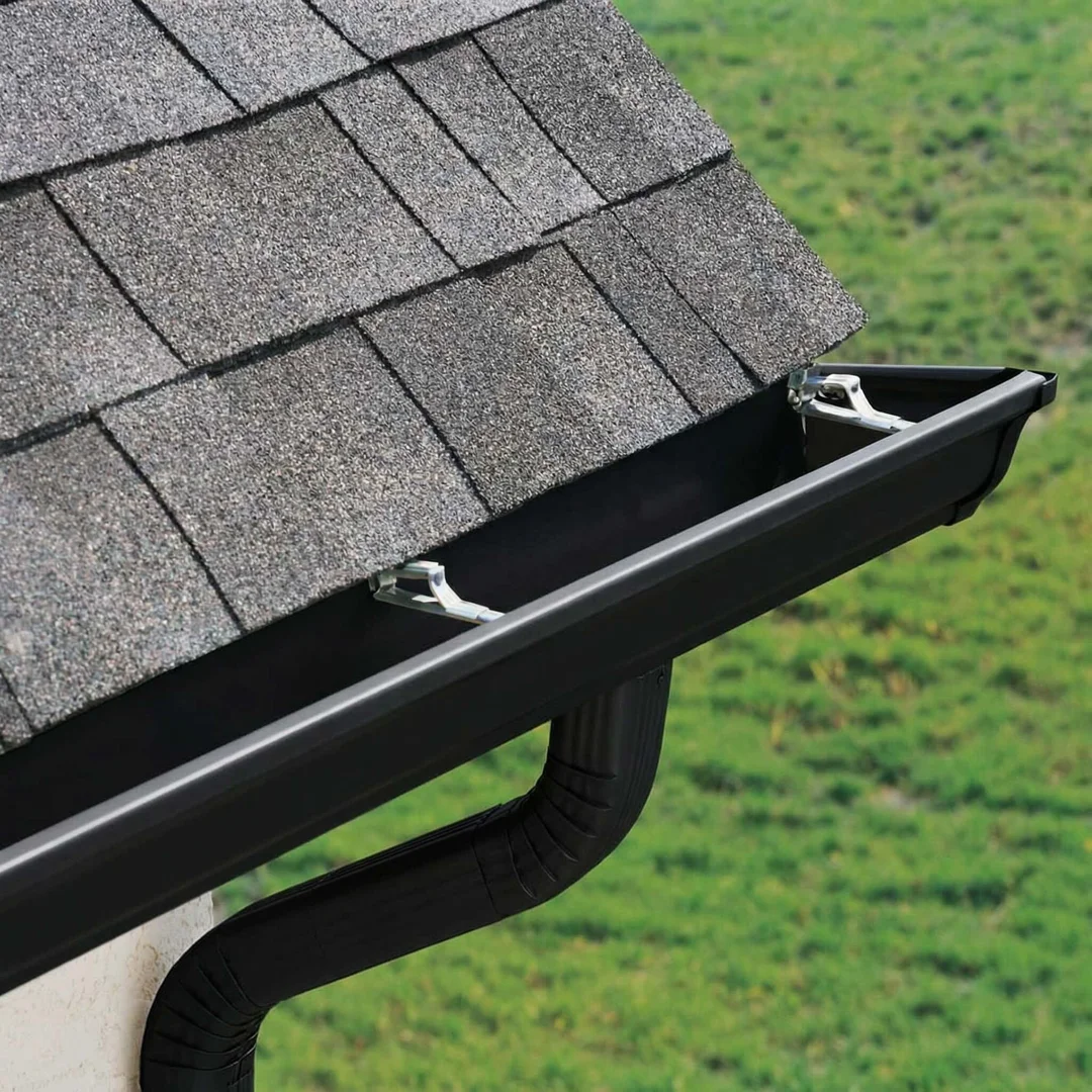 Essential Exterior Maintenance: Roofing and Gutter Care 3 Clean gutters directing water away from a foundation in a Wisconsin setting