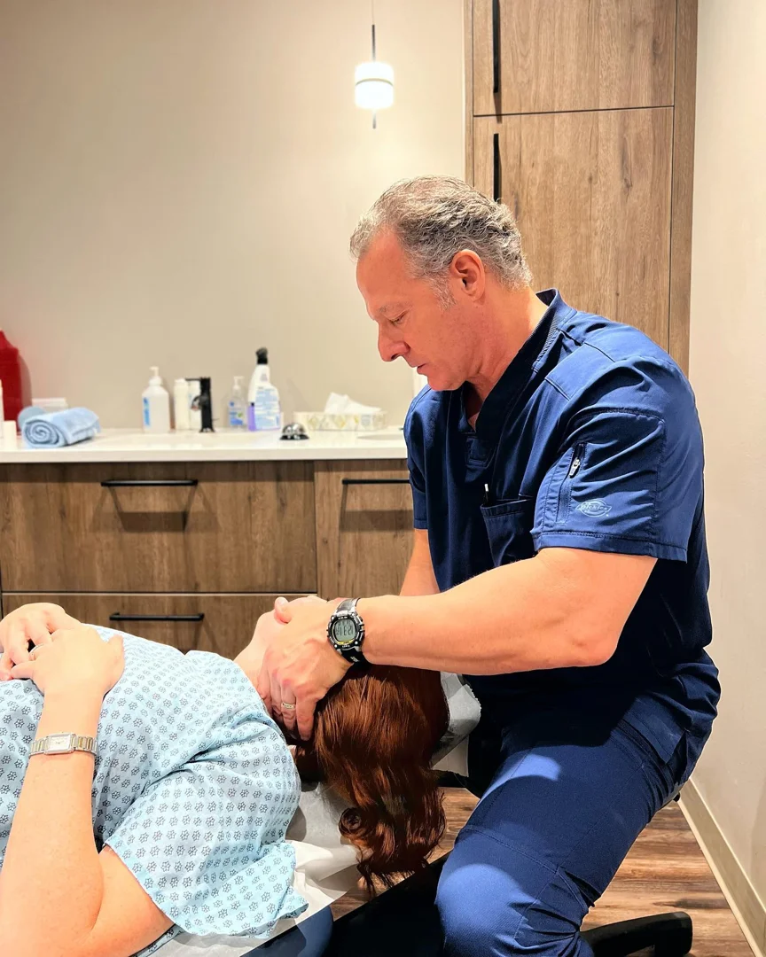 therapist using gentle hands-on diagnostic palpation to assess patient rhythms - integrative manual therapy