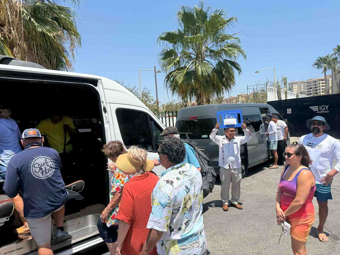 family with luggage boarding cabo san lucas shuttle - cabo san lucas shuttle