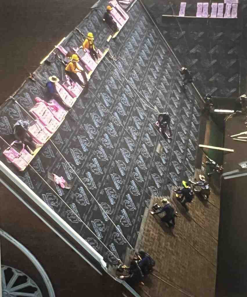 roofers wearing safety harnesses on steep roof - roof installation