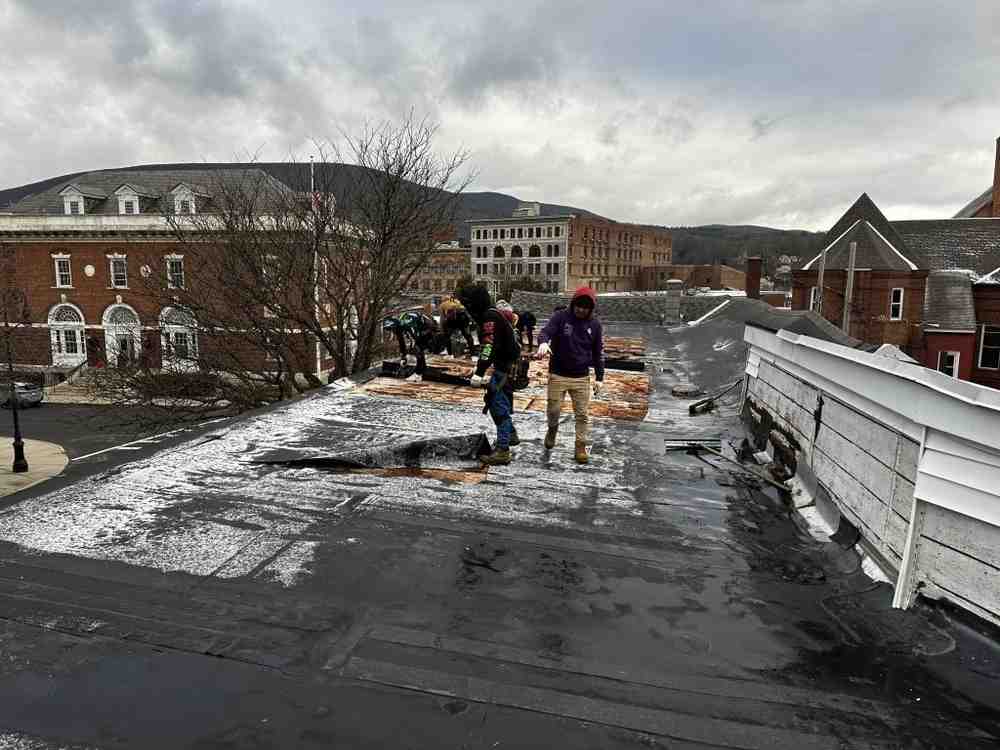 contractor on a flat roof performing an inspection - Flat Roofing Contractor