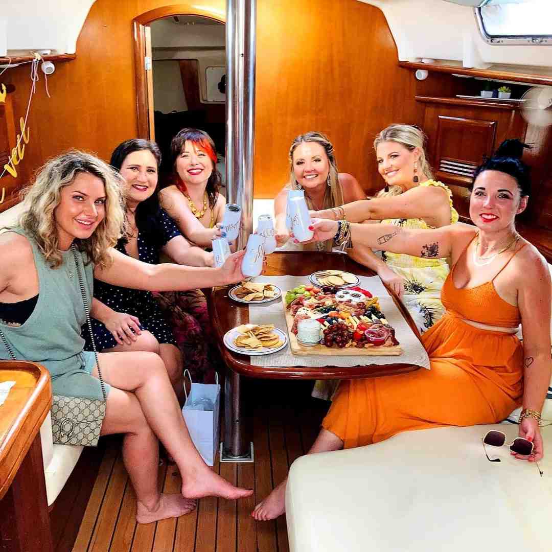 Spacious, neat yacht set for a group dinner, contrasted with an intimate private table on deck - dinner cruise charleston