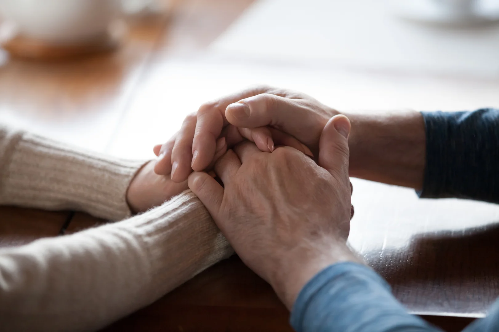 Close-up of hands resting gently on a warm, textured linen blanket Close-up of hands resting gently on a warm, textured linen blanket