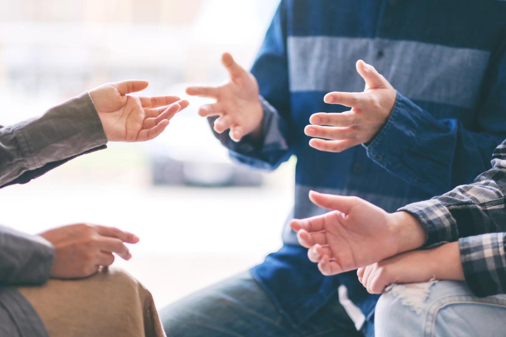 therapy infidelity couples in emotional crisis close-up of hand gesture when three people talking - therapy infidelity