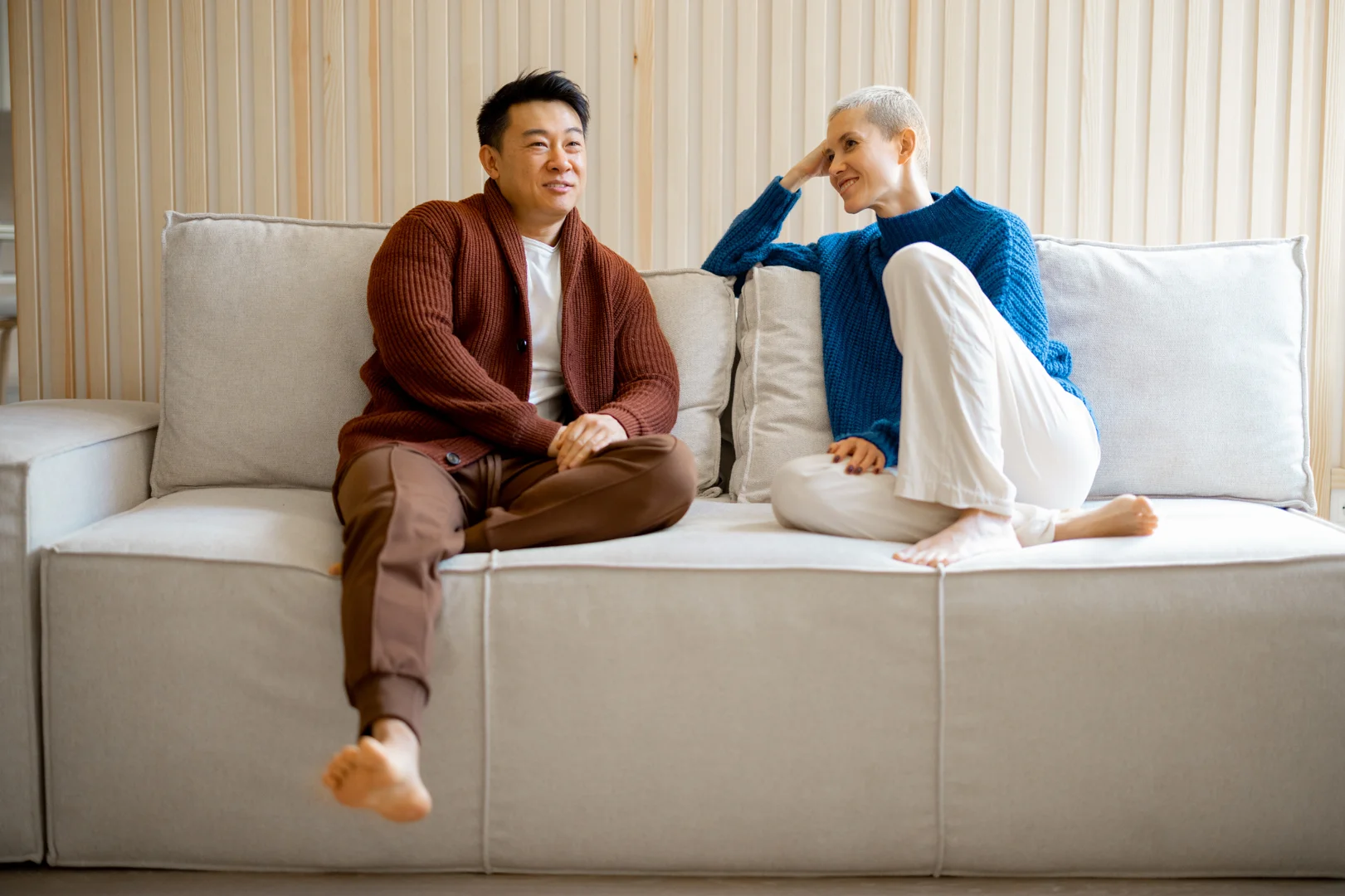 a man and woman sitting on a couch, talking - how marriage counseling works Washington