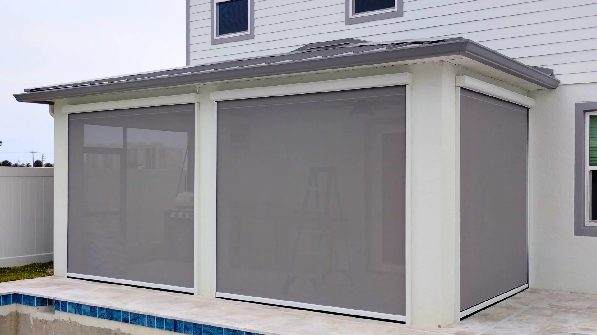 Motorized screen installed within an existing pool enclosure opening