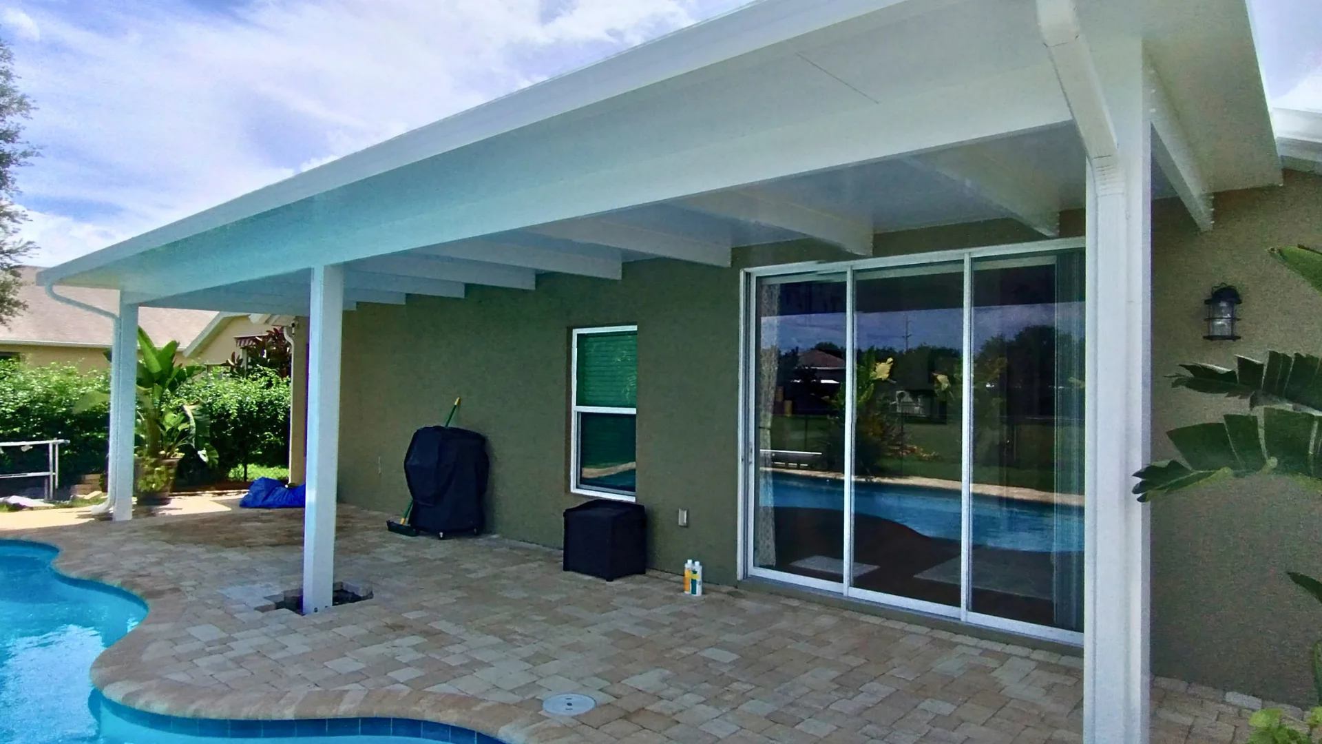 Aluminum pergola beside a residential patio area Aluminum pergola beside a residential patio area