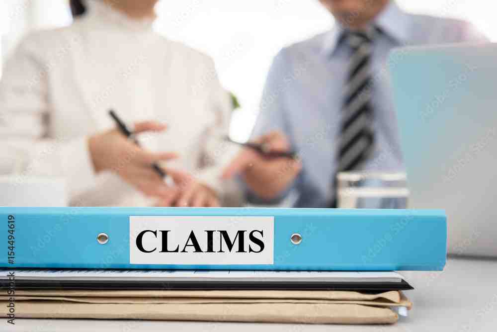 a policyholder reviewing documents with a public adjuster - insurance claim underpaid