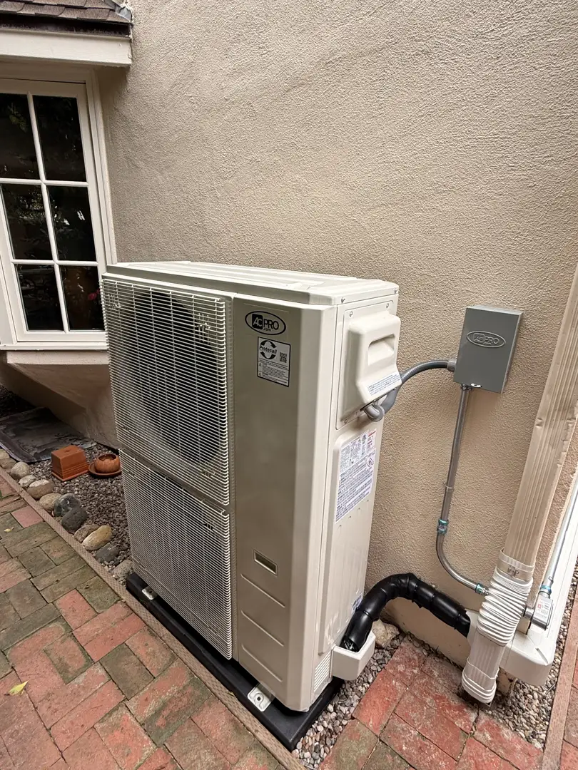 technician inspecting a modern heat pump unit in a sunny San Diego backyard - heat pump benefits for southern california