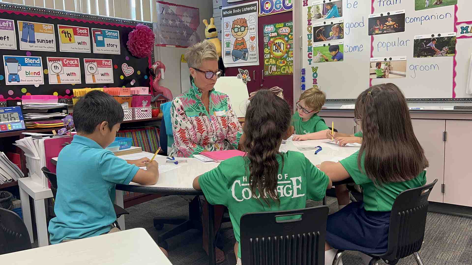 teacher working with students using decodable books - decoding word recognition