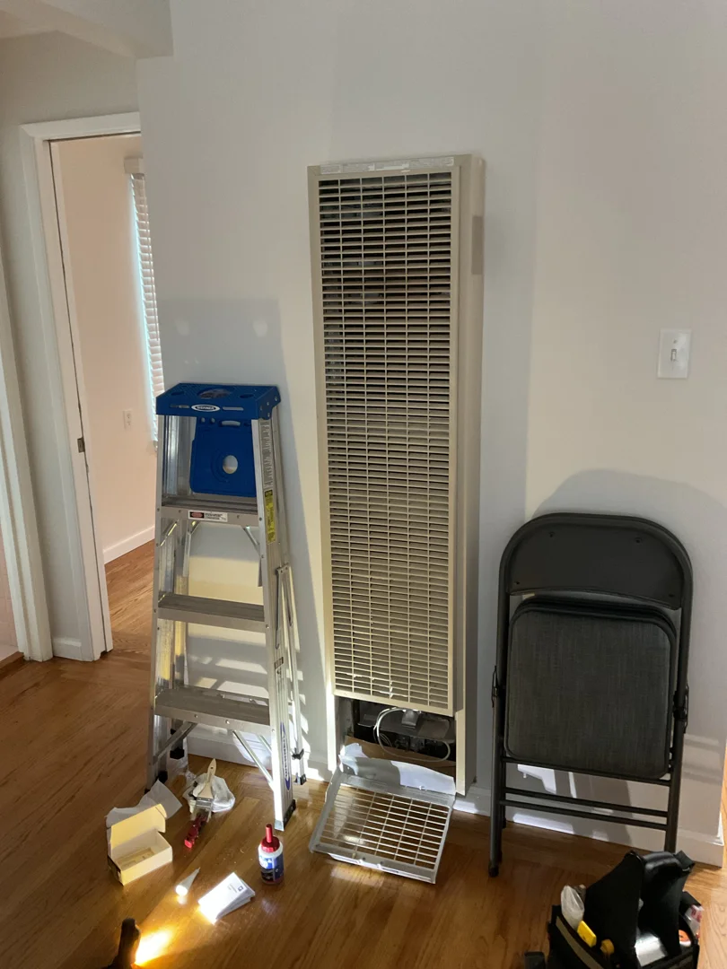 HVAC technician inspecting residential heating and cooling system indoors HVAC technician inspecting residential heating and cooling system indoors