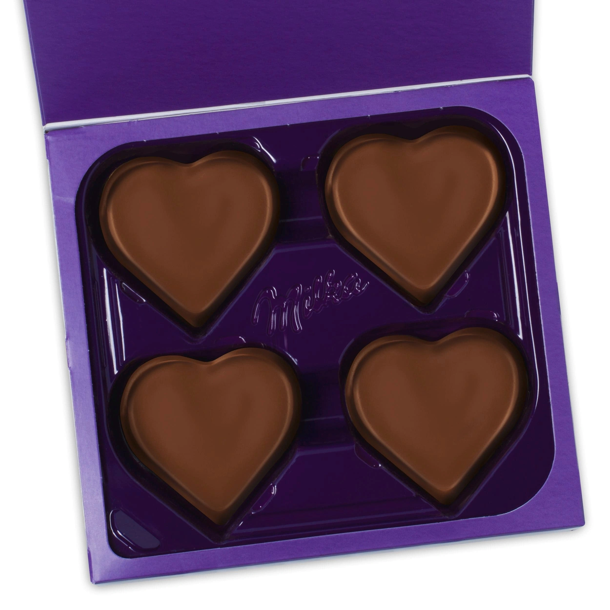 Открытая коробка Milka с четырьмя шоколадными сердечками во внутреннем лотке