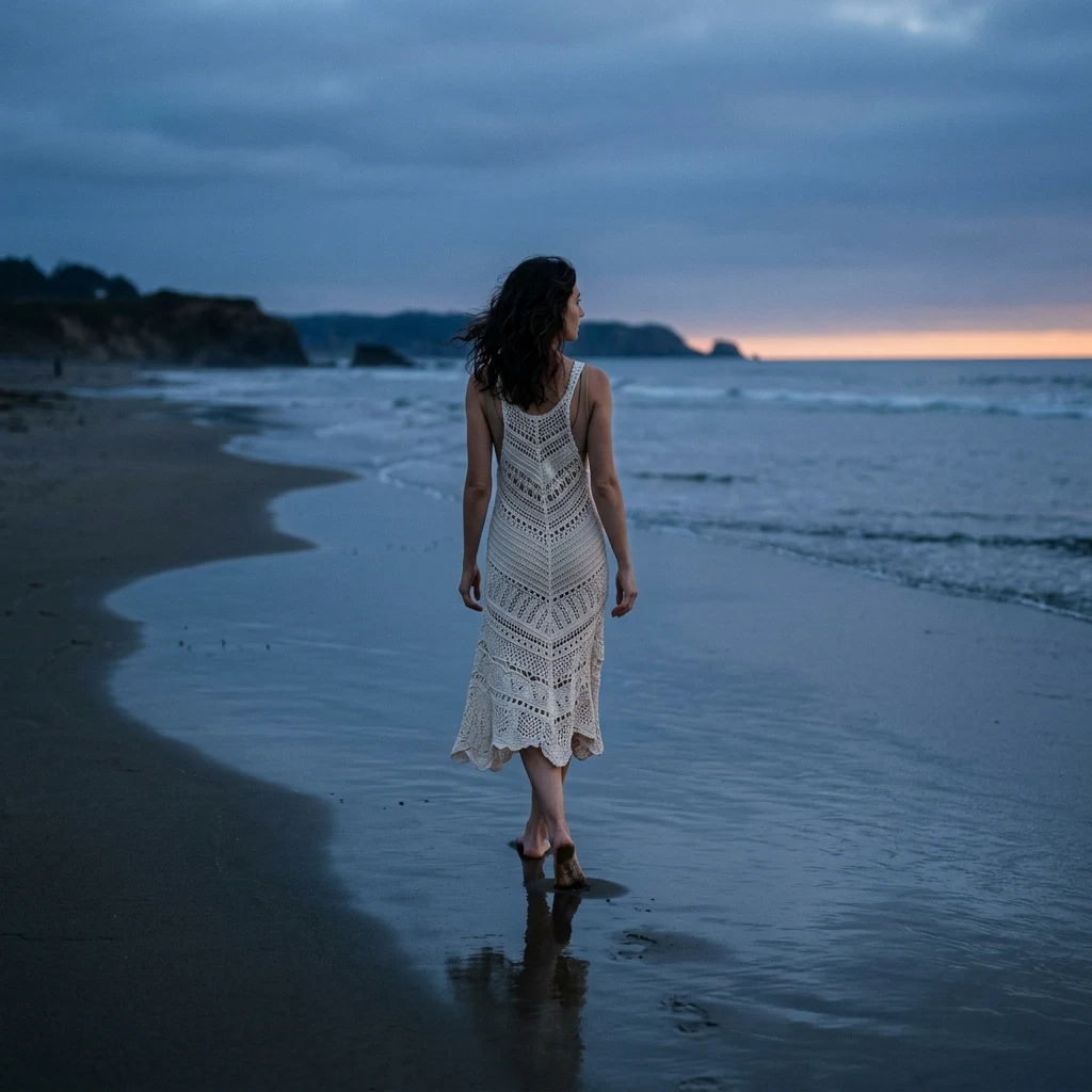 A beach-ready crochet-knit midi dress in ivory over a neutral swimsuit