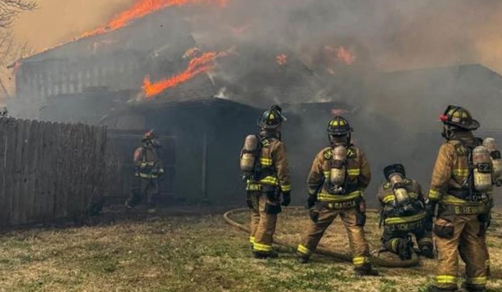 Bomberos combatiendo llamas en vivienda