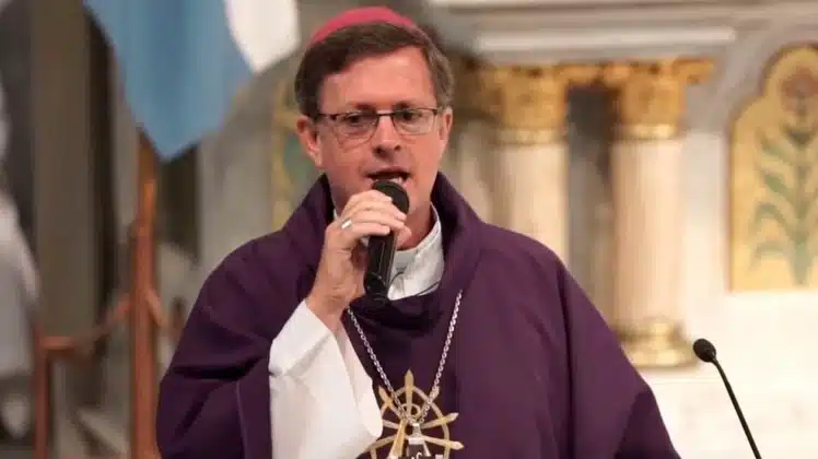 Religioso con sotana morada hablando en evento solemne