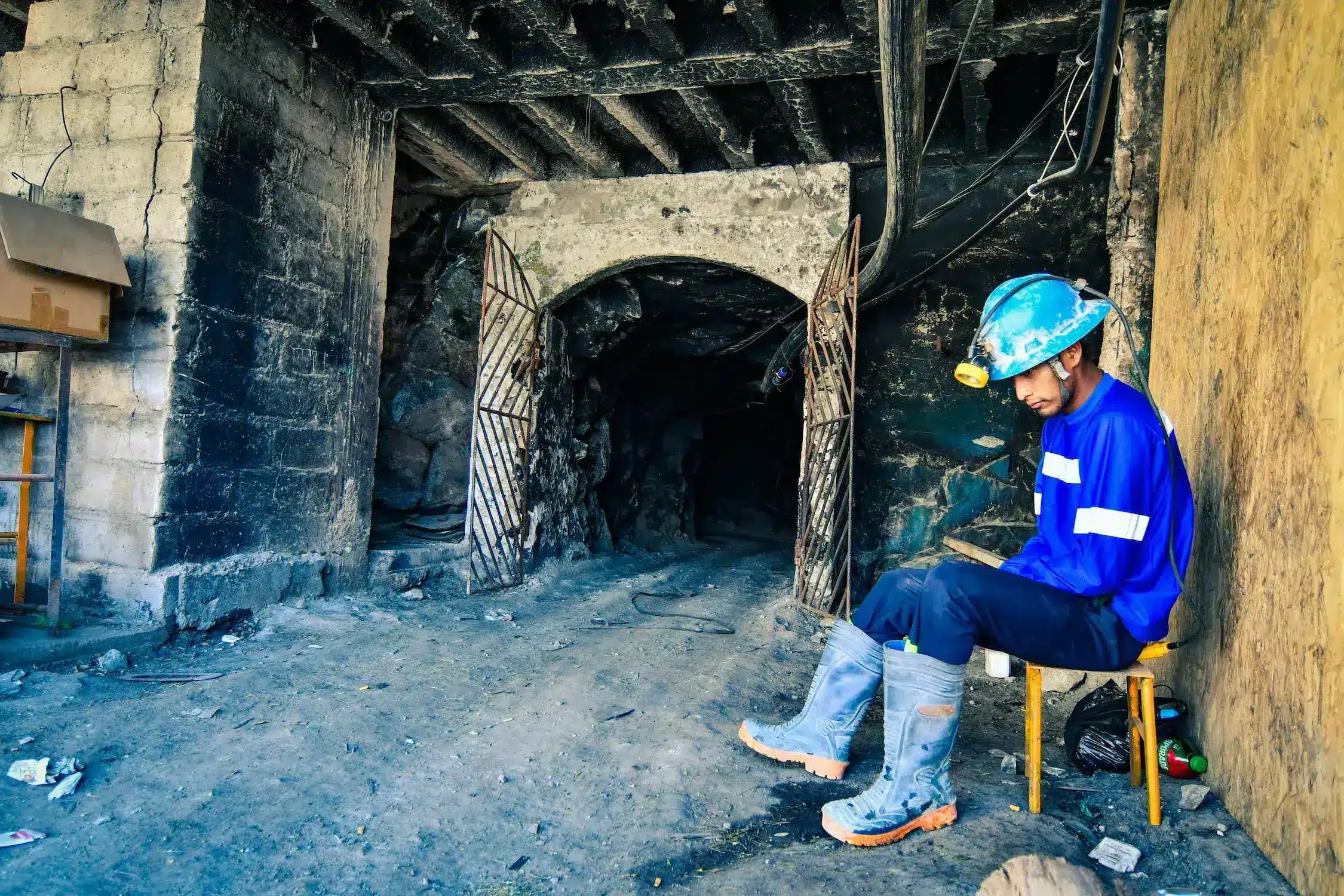Trabajador minero con equipo de seguridad en entrada de mina