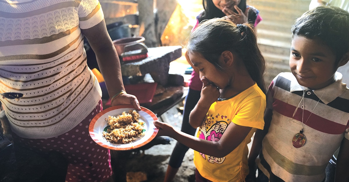 Mujer entrega comida a ni&ntilde;a en Hait&iacute;