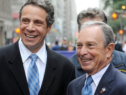 Mike Bloomberg y Andrew Cuomo conversando en evento p&uacute;blico