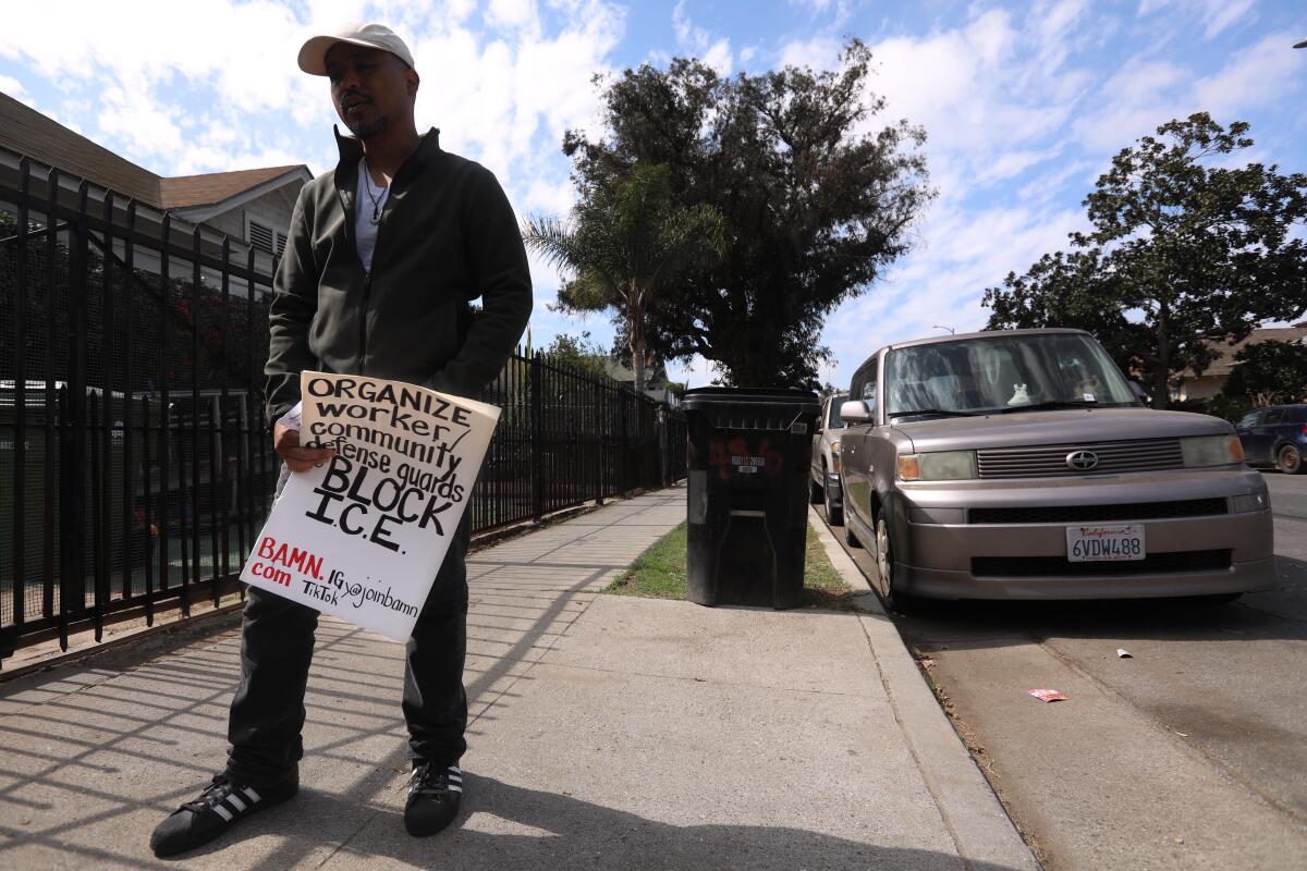 Manifestante con cartel contra redadas de ICE