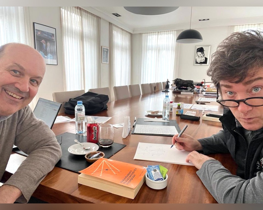 Sturzenegger y Milei en reuni&oacute;n con libro de microeconom&iacute;a visible