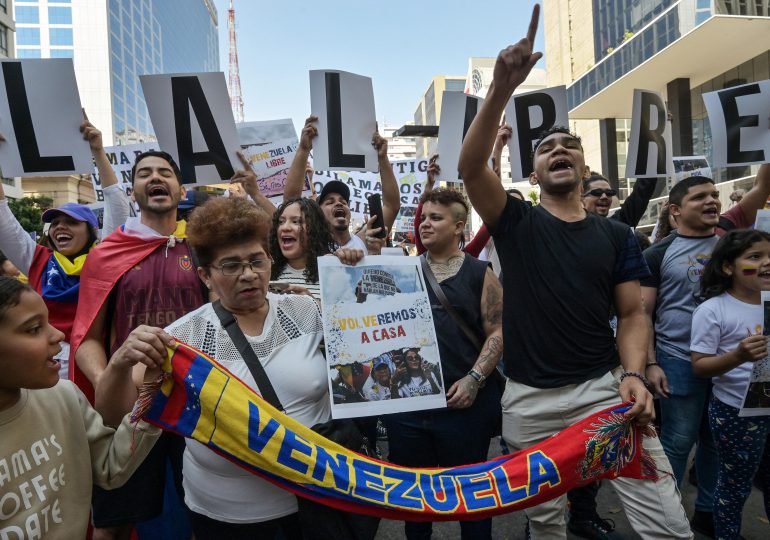 Manifestantes con carteles de libertad y bandera venezolana