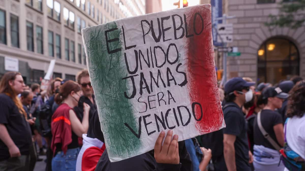 Manifestante con cartel 'El pueblo unido jamás será vencido'