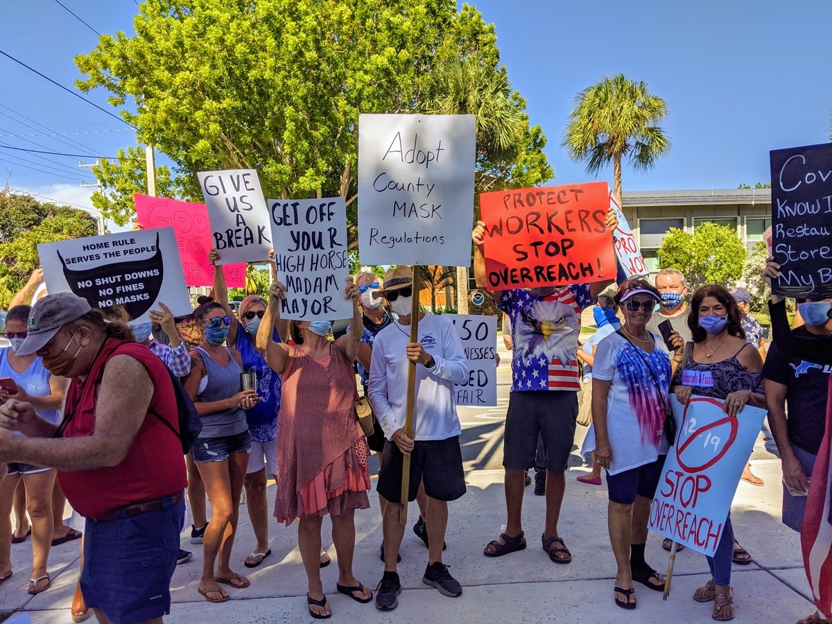 Grupo de manifestantes sosteniendo carteles contra pol&iacute;ticas municipales