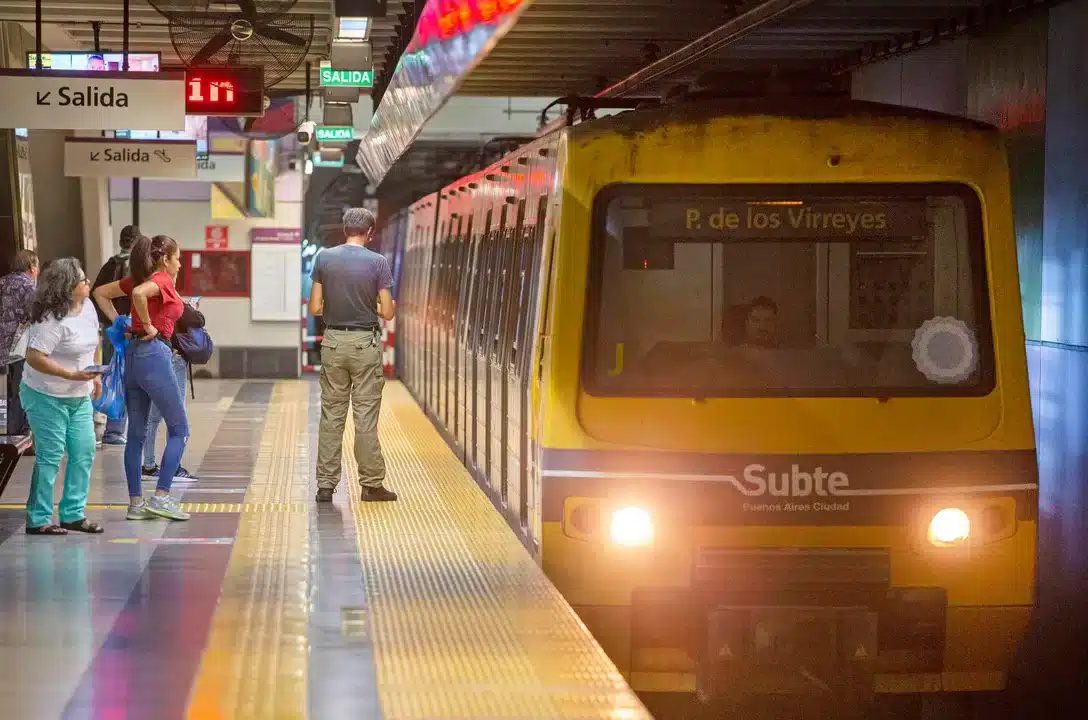 Estación de subte en Buenos Aires con tren amarillo y pasajeros