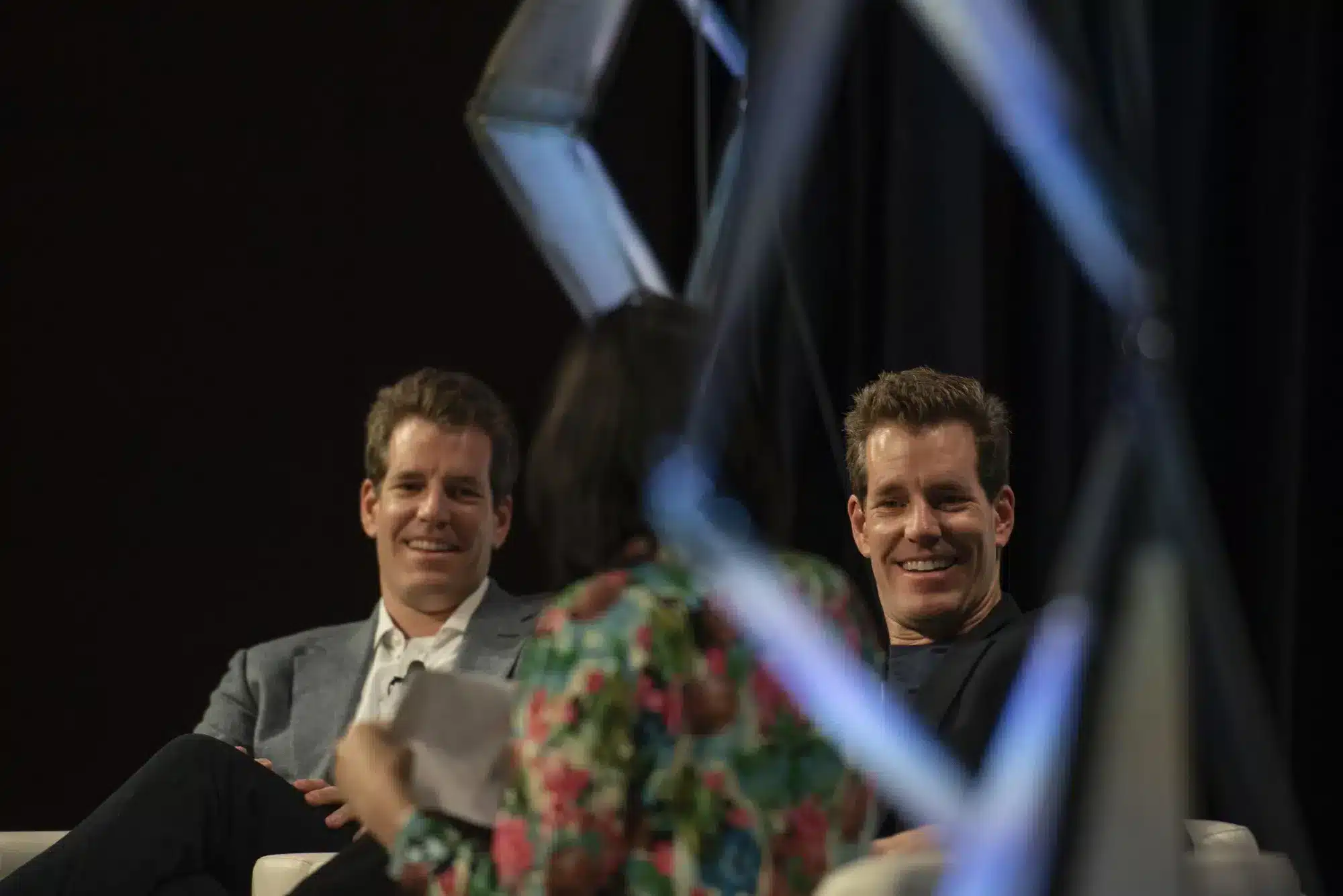 Gemelos Winklevoss sonriendo en panel de discusi&oacute;n sobre criptomonedas