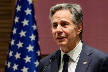 Hombre realizando discurso con bandera estadounidense de fondo