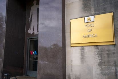 Fachada del edificio de Voice of America con letrero dorado y s&iacute;mbolo de la organizaci&oacute;n