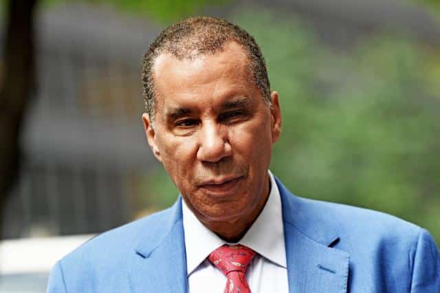 Hombre de piel clara con traje azul claro y corbata roja